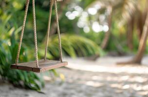 Wooden Swing Hanging in Tropical Garden With Lush Greenery and Sandy Ground photo
