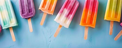 Colorful Ice Cream Popsicles on a Blue Surface With Sprinkles photo