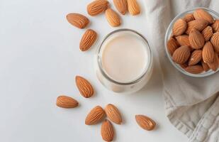 Freshly Made Almond Milk With Raw Almonds on a White Surface photo