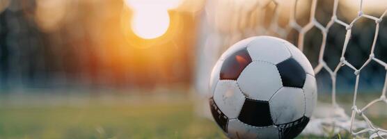 Soccer Ball Nestled in Goal Net at Sunset on a Warm Evening photo
