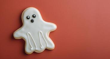 Cute Ghost-Shaped Cookie on Red Background for Halloween Celebration photo