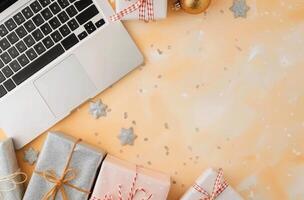Holiday Workspace With Gifts, Christmas Decorations, and Laptop on Bright Yellow Background photo