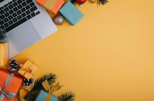 Holiday Workspace With Gifts, Christmas Decorations, and Laptop on Bright Yellow Background photo