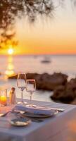 Romantic Sunset Dinner With Wine Glasses by the Ocean photo
