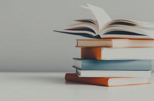 Floating Book Above Stack With Coffee Cup and Decorative Flowers in Minimalist Setting photo