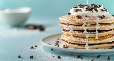 Stack of Pancakes Topped With Whipped Cream and Chocolate Chips on a Plate photo