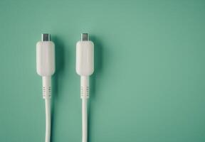 Two White Electrical Plugs on Green Background photo