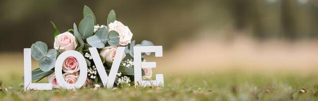 White Love Letters In Front Of Roses photo