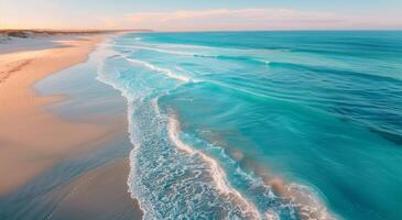 Aerial View of Sandy Beach and Turquoise Ocean Waves photo