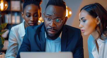 Diverse Team Working on Laptop in Modern Office photo