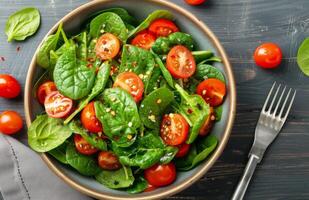 Spinach and Tomato Salad on Wooden Table photo