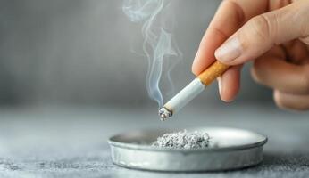 Closeup Of A Lit Cigarette Being Extinguished In An Ashtray photo