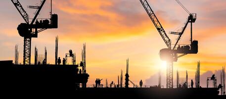 Silhouette of Engineer and workers checking project at building site background, Construction site with blurred sunset in evening time photo