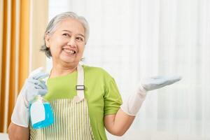 Smiling senior Asian woman housekeeping open hands palm up for your concepts photo