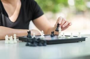 Close up of woman hand playing chess, Asian woman relaxing hobbies playing chess in a park photo