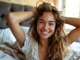 woman sitting in bed woken up stretching arms smiling. photo