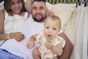 dad playing with his daughters, baby and teenager in a hammock photo