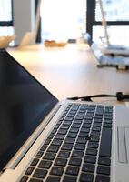 Laptop on a table in a coworking space photo