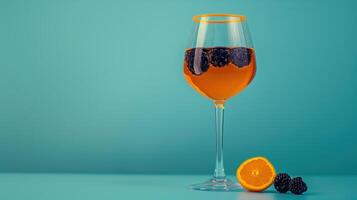 An orange wine glass with blackberries photo