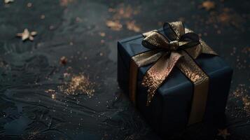 Dark colorful gift box with elegant gold ribbon on dark background photo