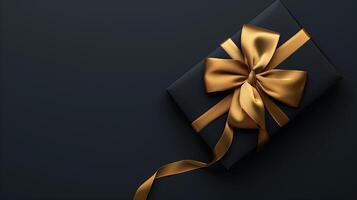 Dark black gift box with elegant gold ribbon photo