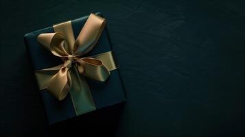 Dark aesthetic gift box with elegant gold ribbon on dark photo