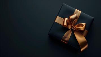 Dark black gift box with elegant gold ribbon photo