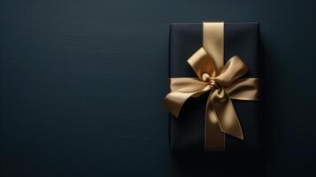 Dark aesthetic gift box with elegant gold ribbon on dark photo
