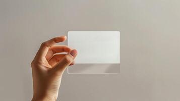 A mockup featuring a hand holding a blank translucent card photo