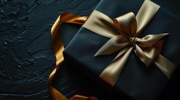 Dark aesthetic gift box with elegant gold ribbon on dark photo