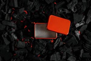 Red metal box on charcoal back. Copy space in a rectangle on a background of hot coals photo