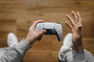 Hand hold new joystick isolated. Gamer play game with gamepad controller. Gaming man holding simulator joypad. Person with keypad joystic in arms. not understanding the situation. Gaming concept. photo
