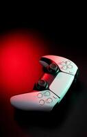 Modern white gamepad illuminated in red and blue. Game controller for games and e-sports on a dark back. photo