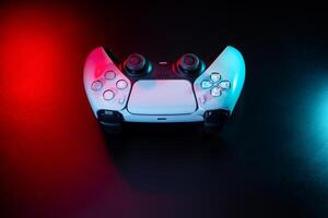 Modern white gamepad illuminated in red and blue. Game controller for games and e-sports on a dark back photo