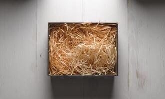 Top view of an open box with packing sawdust. Gift wrapping on the table. photo