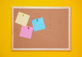 multicolored corkboard stickers pinned with buttons. yellow background. photo