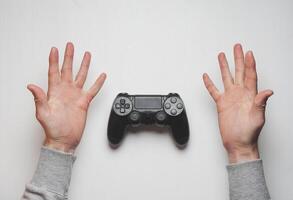 Hand hold new joystick isolated. Gamer play game with gamepad controller. Gaming man holding simulator joypad. Person with keypad joystic in arms. Sleeve hands hold toy equipment. Modern manipulator. photo