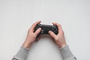 Hand hold new joystick isolated. Gamer play game with gamepad controller. Gaming man holding simulator joypad. Person with keypad joystic in arms. Sleeve hands hold toy equipment. Modern manipulator. photo