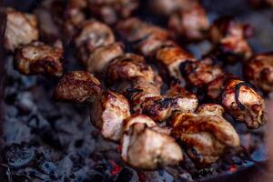 Fresh shish kebab on skewers is fried on the grill. Grilled meat on skewers. photo