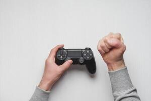 Hand hold new joystick isolated. Gamer play game with gamepad controller. Gaming man holding simulator joypad. Person with keypad joystic in arms. Sleeve hands hold toy equipment. Modern manipulator. photo