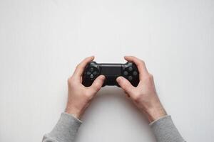 Hand hold new joystick isolated. Gamer play game with gamepad controller. Gaming man holding simulator joypad. Person with keypad joystic in arms. Sleeve hands hold toy equipment. Modern manipulator. photo
