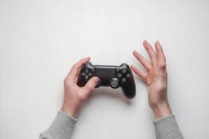 Hand hold new joystick isolated. Gamer play game with gamepad controller. Gaming man holding simulator joypad. Person with keypad joystic in arms. Sleeve hands hold toy equipment. Modern manipulator. photo