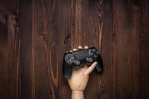 Modern black gamepad on a dark wooden background. Game concept with copy space for text. photo