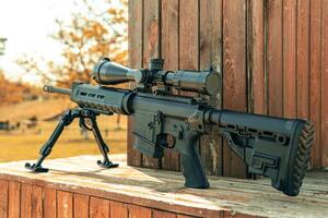 Automatic carbine with a telescopic sight. A sniper weapon mounted on a bipod. Gun for long-range aimed shooting. photo