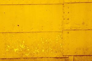 Yellow textural background of old rusty metal sheets fastened together with rivets and nails. photo