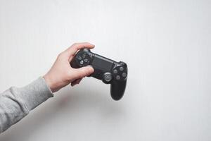 Hand hold new joystick isolated. Gamer play game with gamepad controller. Gaming man holding simulator joypad. Person with keypad joystic in arms. Sleeve hands hold toy equipment. Modern manipulator. photo