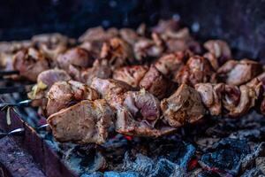 Fresh shish kebab on skewers is fried on the grill. Grilled meat on skewers. photo