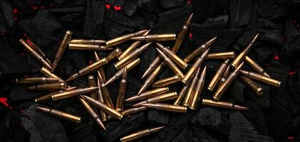 Cartridges for automatic carbine caliber .223 on charcoal. Ammunition for automatic and semi-automatic rifles. Dark back. photo