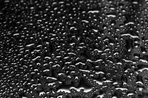 Shiny water drops on a dark glass. Water drops on black surface. photo