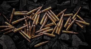 Cartridges for automatic carbine caliber .223 on charcoal. Ammunition for automatic and semi-automatic rifles. Dark back. photo